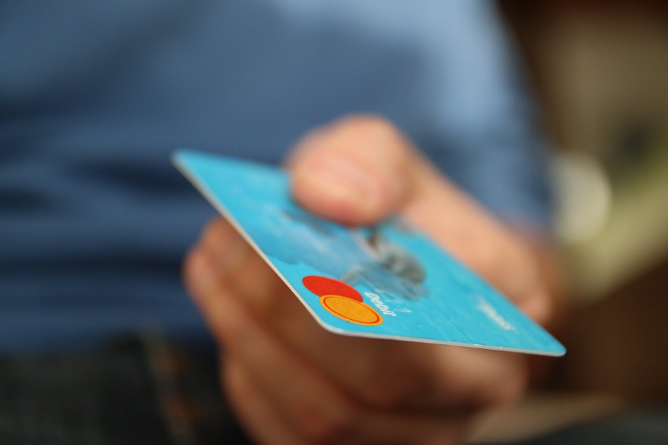 A person handing over a credit card.