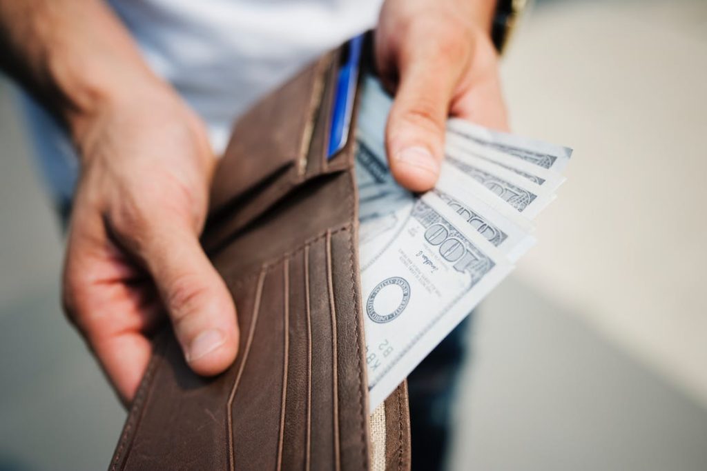 A person pulling money out of their wallet. 